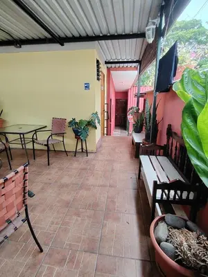 a patio with a table and benches and a table and chairs at Rooms libertad in San Salvador