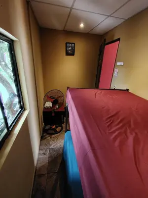 a small room with a bed and a window at Rooms libertad in San Salvador