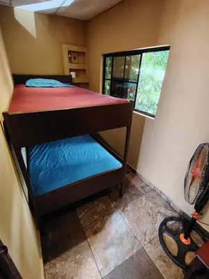 a small room with a bunk bed with a window at Rooms libertad in San Salvador