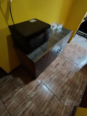 a microwave sitting on top of a wooden counter at Rooms libertad in San Salvador
