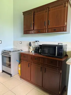 a kitchen with a microwave oven and a stove at Casa en residencial Metrópoli San Gabriel, Nejapa San Salvador in Nejapa