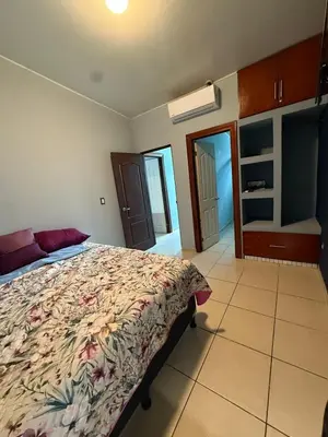 a bedroom with a bed with a floral bedspread at Casa en residencial Metrópoli San Gabriel, Nejapa San Salvador in Nejapa