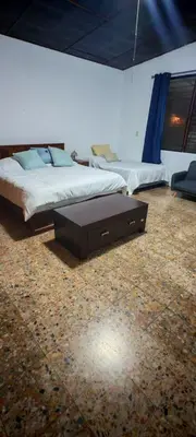 a bedroom with two beds and a table in it at Habitación Lomas de San Francisco in San Salvador