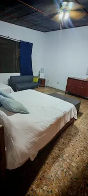 a bedroom with a large bed and a couch at Habitación Lomas de San Francisco in San Salvador