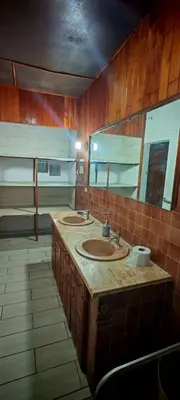 a bathroom with three sinks and a large mirror at Habitación Lomas de San Francisco in San Salvador