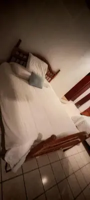 a wooden bed with white sheets and pillows at Habitación Lomas de San Francisco in San Salvador