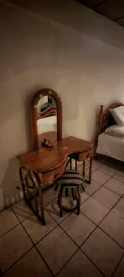 a wooden table and chair in a room with a bed at Habitación Lomas de San Francisco in San Salvador