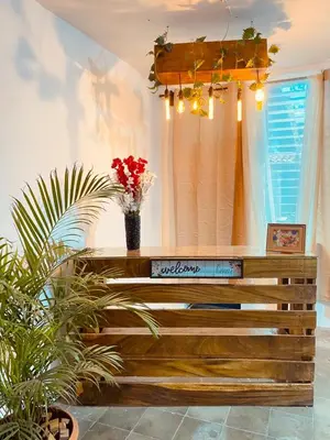a room with a bench with flowers and a chandelier at Hostal La casa de Ross in Santa Ana