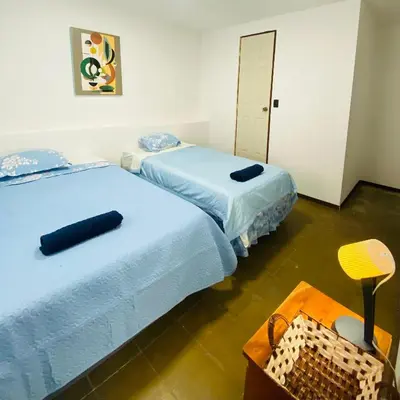 two beds sitting next to each other in a room at Hostal La casa de Ross in Santa Ana