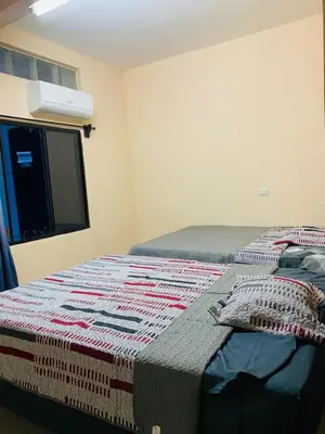 a bedroom with a bed with a quilt on it at Hostal La casa de Ross in Santa Ana