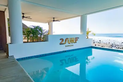 a swimming pool with a view of the beach at 2Surf Sunzal in El Sunzal