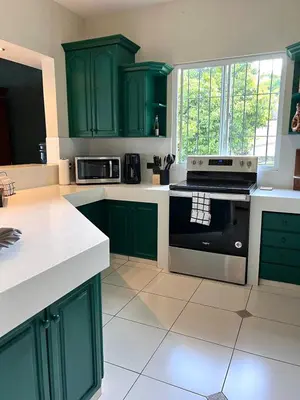 a kitchen with green cabinets and a stove at Quinta Avanti Villa-Coatepeque Lake-14 guest in Santa Ana