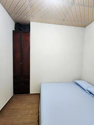 a bedroom with a white bed and a wooden cabinet at House Moma