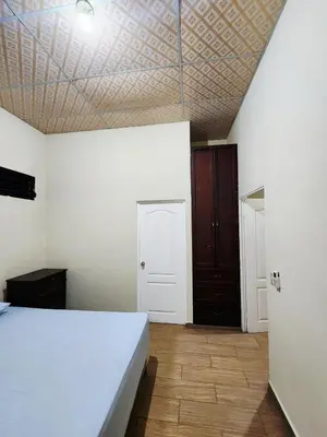 a bedroom with a white bed and a wooden floor at House Moma