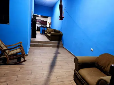 a living room with blue walls and a couch and chairs at House Moma
