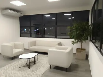 a living room with white furniture and a potted plant at Apartamento YOU D6 in San Salvador