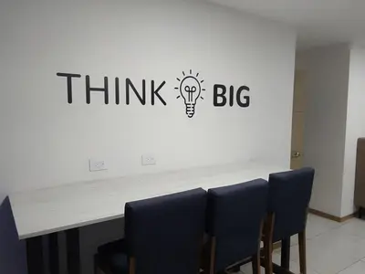 a think big sign on a wall with a light bulb on it at Apartamento YOU D6 in San Salvador