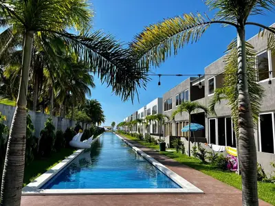 a canal with palm trees in front of a building at Sunsets Apartment in San Luis La Herradura