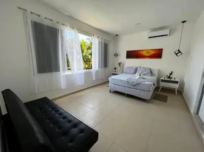 a living room with a couch and a bed and window at Sunsets Apartment in San Luis La Herradura