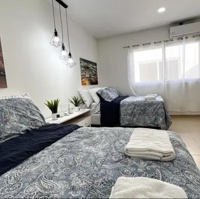 a bedroom with two beds and a window at Sunsets Apartment in San Luis La Herradura
