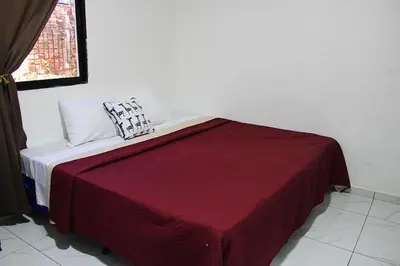 a bed with a red blanket and two pillows on it at Hotel D' Palacio Real in San Miguel