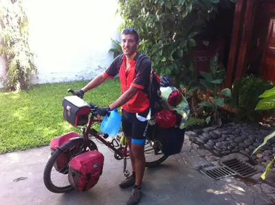 a man is standing next to a bike at Hotel Caleta in San Miguel