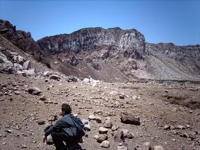 a person with a backpack on a rocky mountain at Hotel Caleta in San Miguel