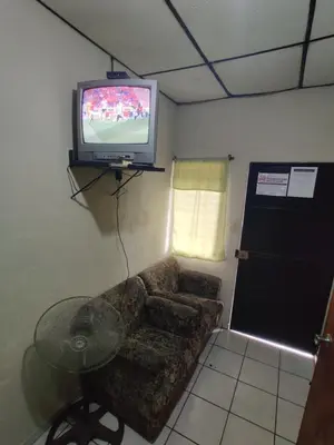 a living room with a couch and a tv at Hotel en Santa Ana in Santa Ana