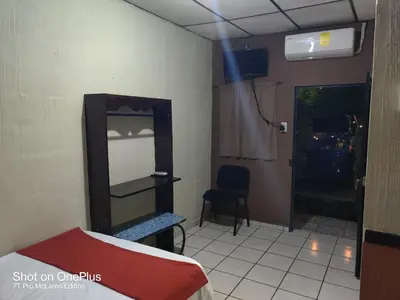 a room with a bed and a mirror and a chair at Hotel en Santa Ana in Santa Ana
