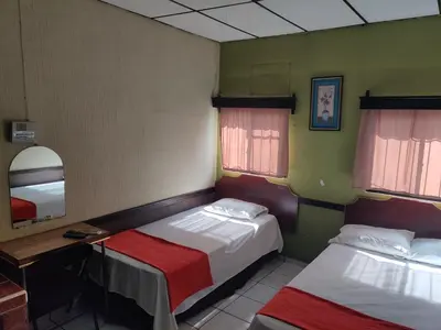 a small room with two beds and a mirror at Hotel en Santa Ana in Santa Ana