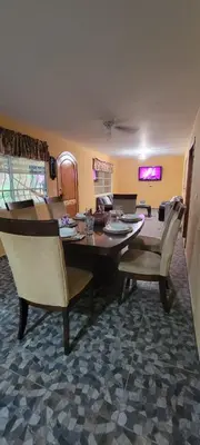 a dining table and chairs in a living room at Kinta Mae Foster in Marcelino