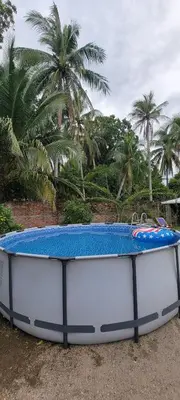 a blue and white surfboard sitting on the ground at Kinta Mae Foster in Marcelino