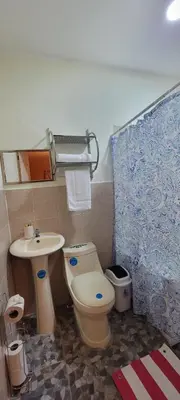 a bathroom with a toilet and a sink at Kinta Mae Foster in Marcelino