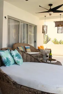 a living room with a wicker couch with pillows at Kailani, Costa del Sol in San Luis La Herradura