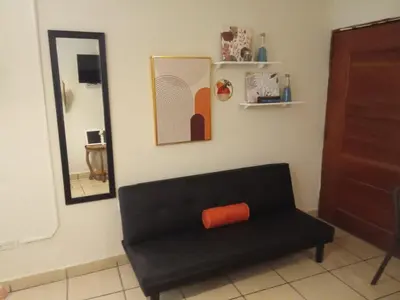 a black couch in a room with a mirror at Cozy Loft,Surf City, La Libertad, in La Libertad