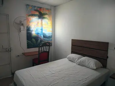 a bedroom with a bed and a painting on the wall at Lombardia San Salvador City in San Salvador
