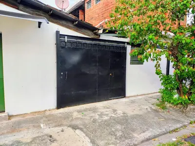 a black garage door on the side of a house at Lombardia San Salvador City in San Salvador