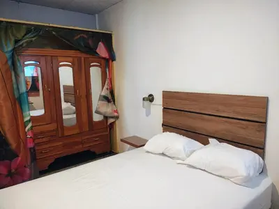 a bedroom with a bed with two white pillows at Lombardia San Salvador City in San Salvador