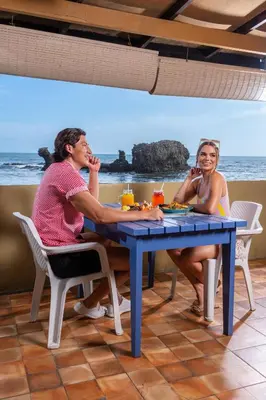 two women sitting at a table on the beach at Hotel Roca Sunzal in La Libertad