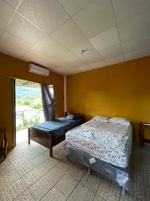 a bedroom with two beds and a window at Casa de Playa en Atami, La Libertad, El Salvador in El Zonte