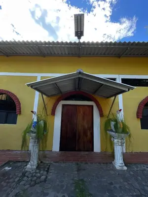 a yellow and white house with a wooden door at Casa de Playa en Atami, La Libertad, El Salvador in El Zonte