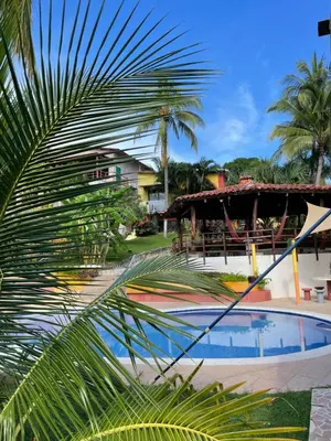 a palm tree in front of a swimming pool at Casa de Playa en Atami, La Libertad, El Salvador in El Zonte