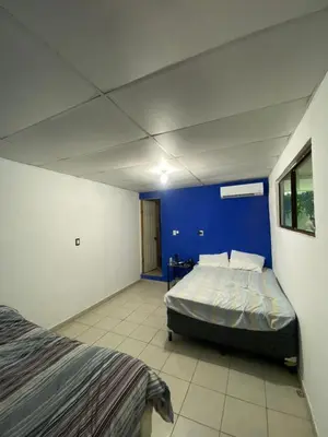 a bedroom with a bed and a blue wall at Casa de playa acogedora en San Diego, La Libertad, El Salvador in San Diego