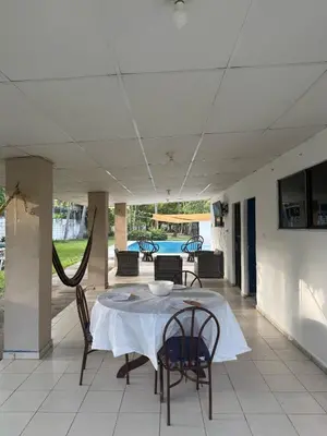 a table and chairs on a patio with a table and a television at Casa de playa acogedora en San Diego, La Libertad, El Salvador in San Diego