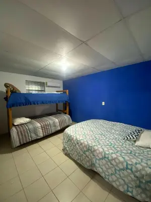 a bedroom with a bed and a blue wall at Casa de playa acogedora en San Diego, La Libertad, El Salvador in San Diego