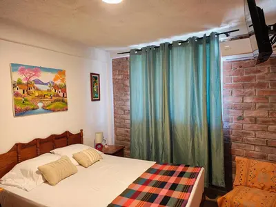 a bedroom with a bed and a brick wall at Lombardia Planes de Renderos in San Marcos