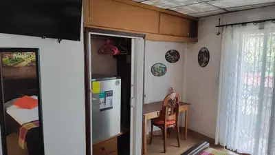a small kitchen with a table and a refrigerator at Lombardia Planes de Renderos in San Marcos