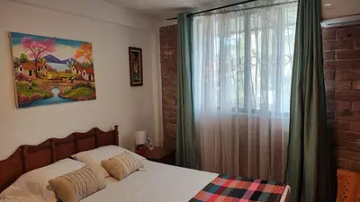 a bedroom with a bed and a large window at Lombardia Planes de Renderos in San Marcos