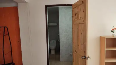 a bathroom with a toilet and a glass door at Lombardia Planes de Renderos in San Marcos