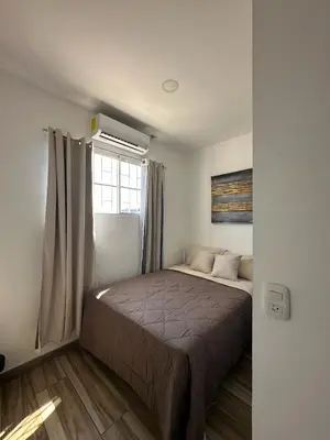 a bedroom with a bed in a room with a window at Apartamento C Fuertevali in San Salvador